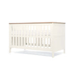 White cot bed with natural top showing highest base position on a white background