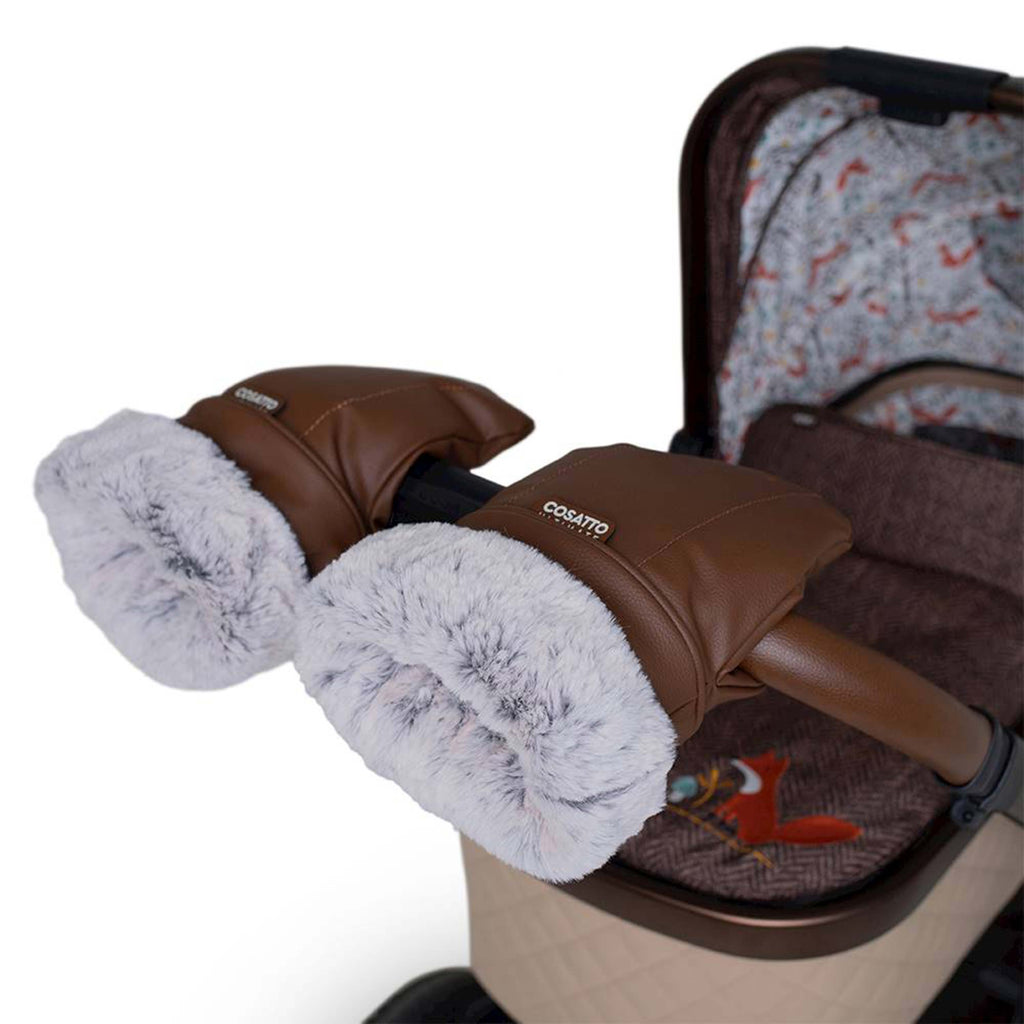 Brown stroller heated mitts with fluffy light grey faux fur lining, branded 'cosatto', shown on a stroller against a white background.