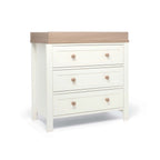 White dresser with three drawers and a natural top changer frame on a white background