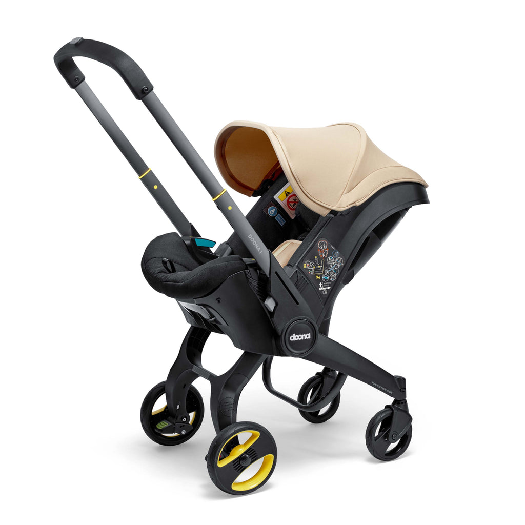 Doona Black and beige stroller with a baby seat on a white background