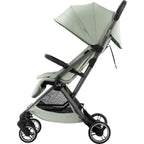 A compact stroller with a light sage green fabric body and a grey frame , shown from the side against a plain white background.