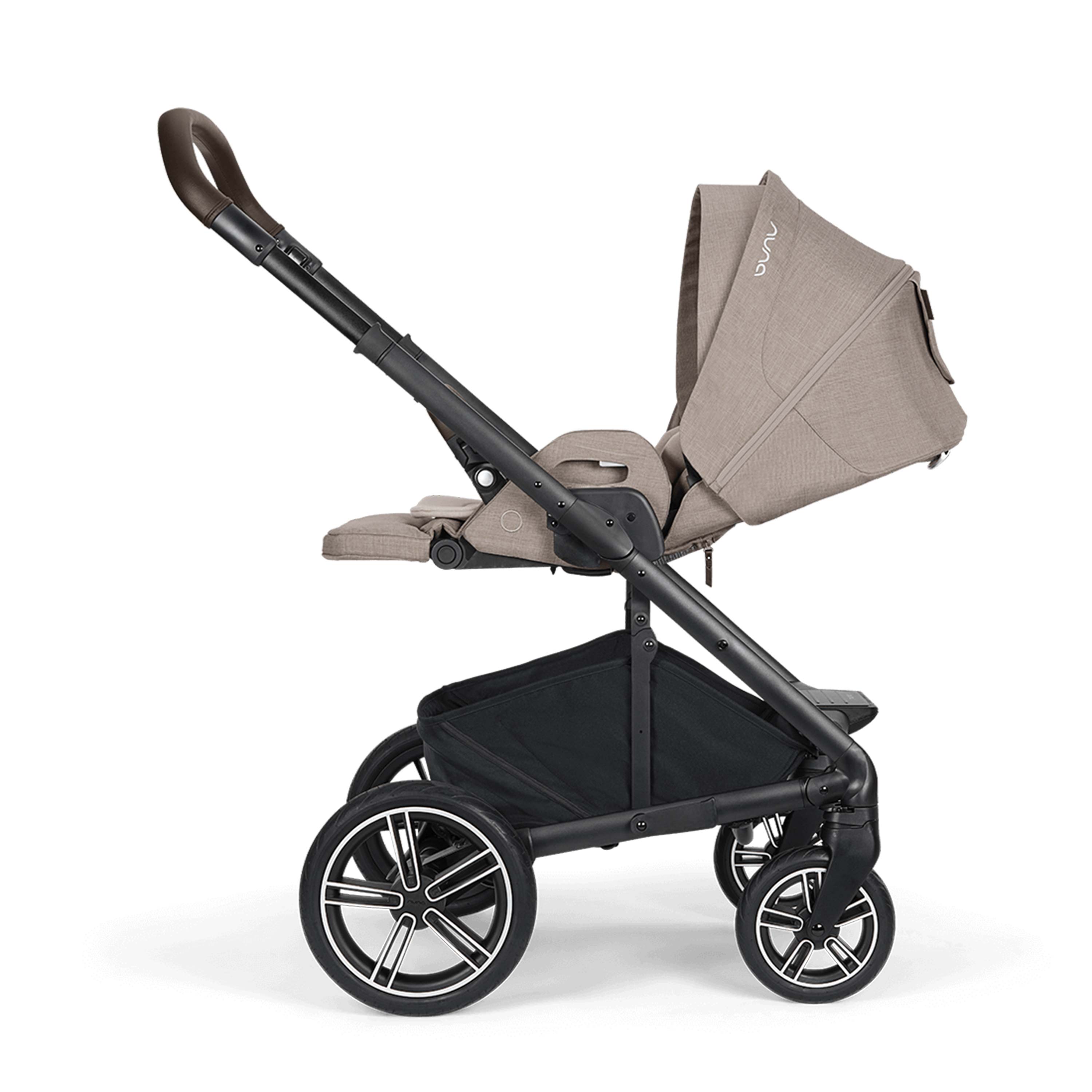 Baby stroller reclined side view with beige canopy on a white background